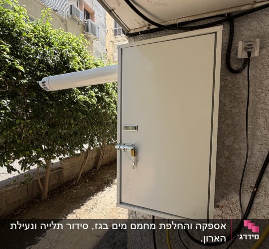 ארון גז מותקן על קיר חיצוני עם צינורות